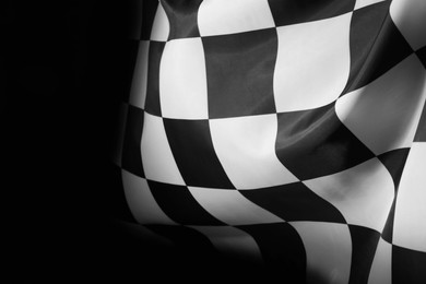 Photo of Checkered finish flag on black background, closeup