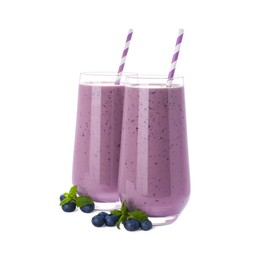 Glasses of blueberry smoothie with fresh berries and mint on white background