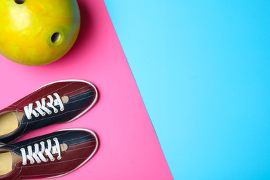 Bowling ball and shoes on color background, flat lay. Space for text