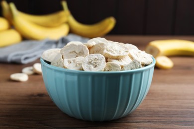Freeze dried and fresh bananas on wooden table, closeup