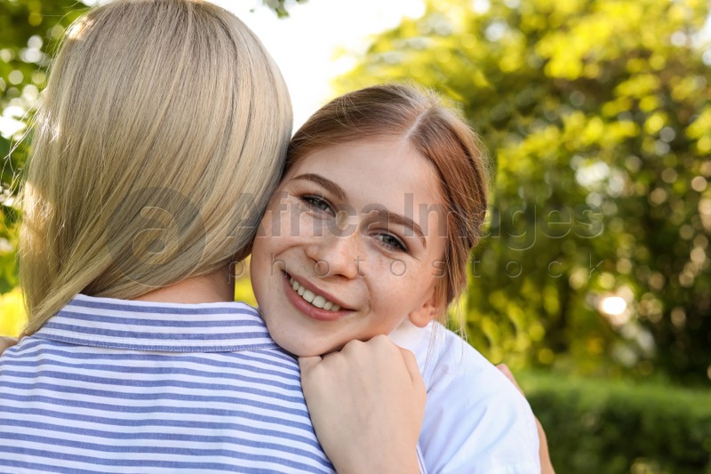 Happy daughter with her mother spending time together in park on sunny day