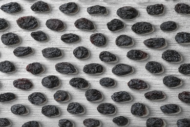 Flat lay composition with raisins on white wooden background. Dried fruit as healthy snack
