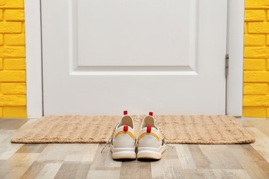 Shoes and mat near door in hallway