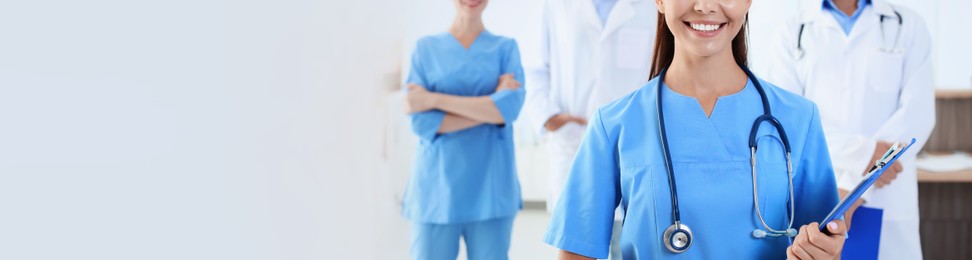 Doctor in uniform with stethoscope at workplace, space for text. Banner design