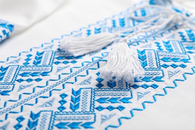 Beautiful white shirt with light blue Ukrainian national embroidery, closeup