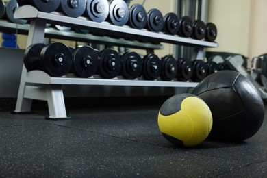 Medicine balls on floor in gym, space for text