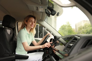 Photo of Young woman using navigation system while driving car