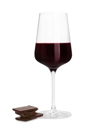 Glass of red wine and delicious chocolate pieces on white background