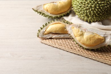 Fresh ripe durians on light wooden table. Space for text