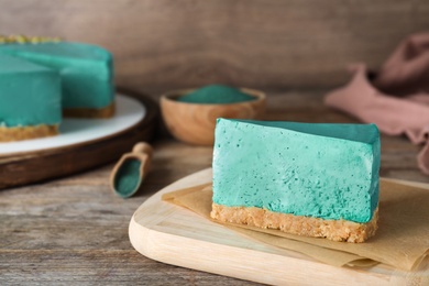 Piece of delicious homemade spirulina cheesecake on wooden table