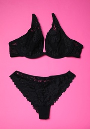 Set of black lace lingerie on pink background, flat lay