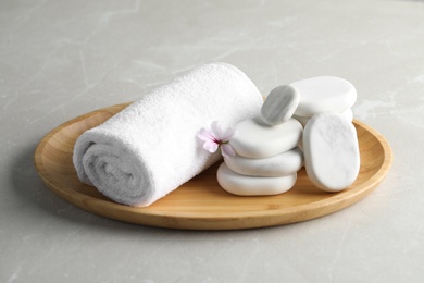 Photo of Spa stones, towel and fresia flower on light table