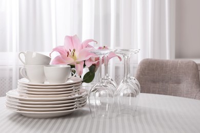 Set of clean dishware and wine glasses on table indoors