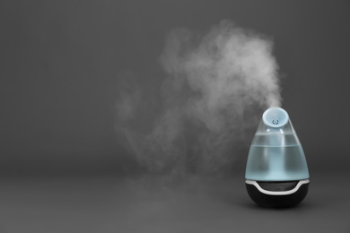Modern air humidifier on grey background. Space for text