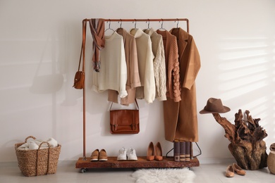 Photo of Modern dressing room interior with rack of stylish shoes and women's clothes