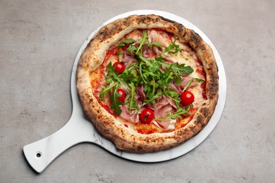 Tasty pizza with meat and arugula on grey table, top view