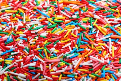 Bright colorful sprinkles as background, closeup. Confectionery decor