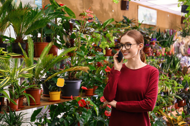Female business owner talking on mobile phone in flower shop