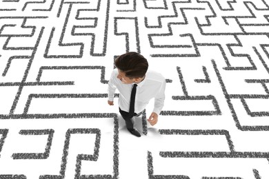 Thoughtful businessman and illustration of maze on white background