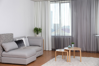 Window with stylish curtains in living room interior