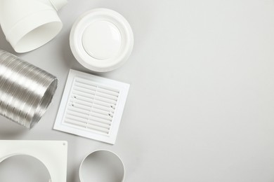Parts of home ventilation system on light grey background, flat lay. Space for text