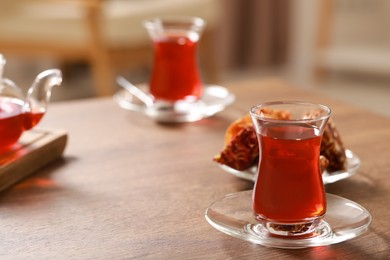 Photo of Glasses with traditional Turkish tea on wooden table, space for text