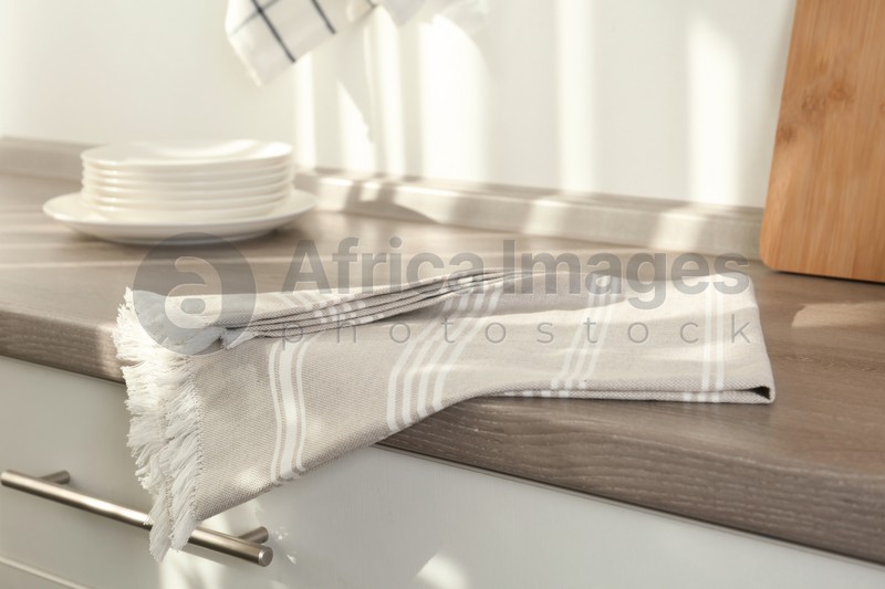 Light grey cotton towel on wooden table in kitchen
