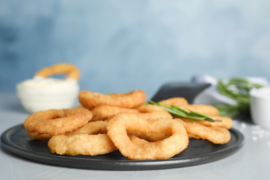 Fried onion rings served on grey table