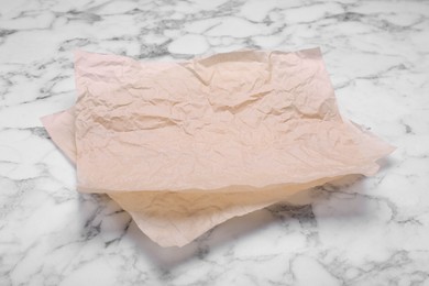 Photo of Sheets of baking paper on white marble table