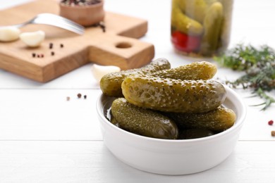 Tasty pickled cucumbers on white wooden table, space for text
