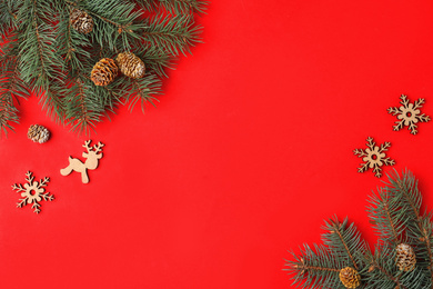 Photo of Christmas flat lay composition with fir branches on red background, space for text. Winter holidays