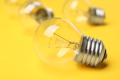 New incandescent lamp bulb on yellow background