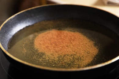 Frying pan with used cooking oil on stove, closeup