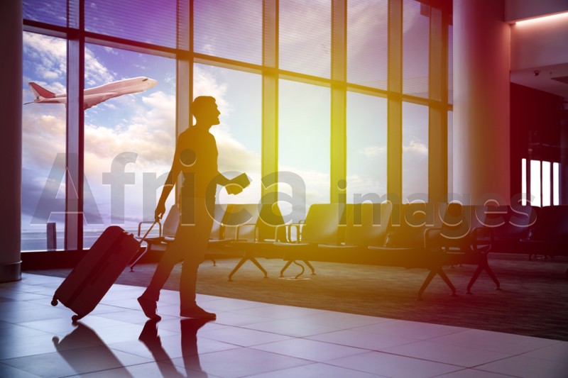 Silhouette of man with suitcase in airport