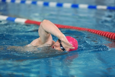 Young athletic man swimming in pool