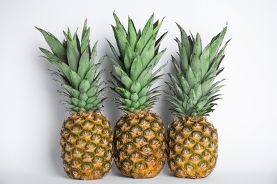 Photo of Fresh ripe juicy pineapples on white background