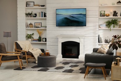 Photo of Cozy living room interior with comfortable sofa, armchairs and decorative fireplace