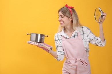 Young housewife with pot on yellow background