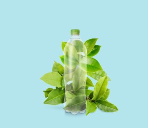 Bottle made of biodegradable plastic and green leaves on light blue background