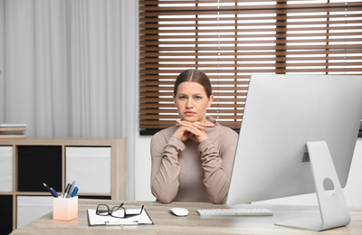 Professional psychotherapist at table with computer in modern office