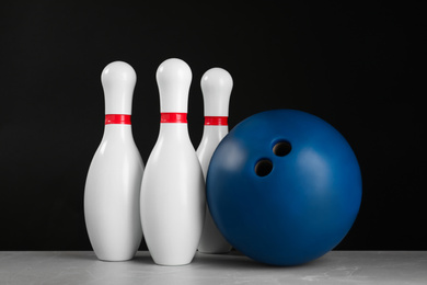 Blue bowling ball and pins on light grey marble table