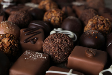 Different delicious chocolate candies as background, closeup