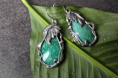 Beautiful pair of silver earrings with amazonite gemstones on green leaf, above view
