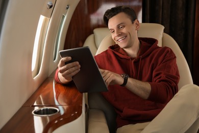 Young man using tablet in airplane during flight