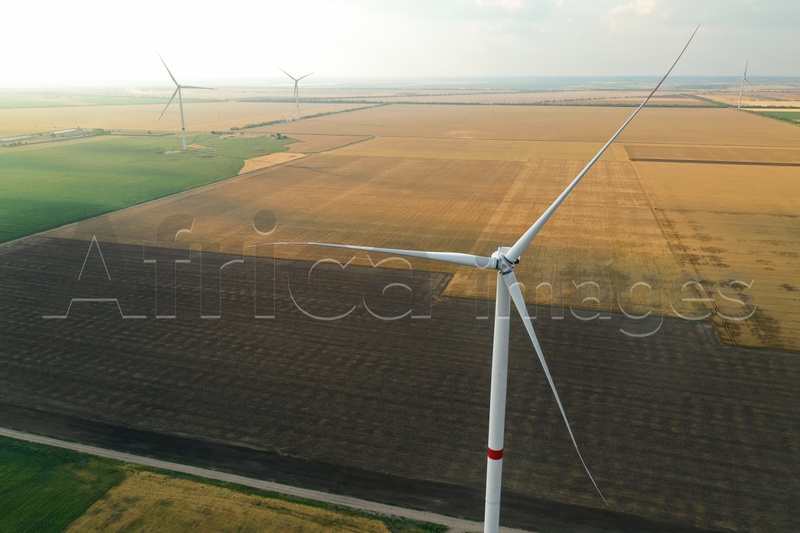 Photo of Modern windmill in wide field. Energy efficiency