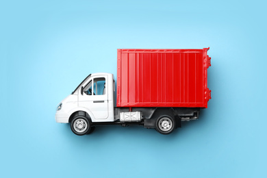 Top view of toy truck on blue background, space for text. Logistics and wholesale concept