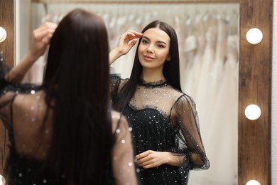 Woman trying on dress in clothing rental salon