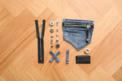 Photo of Flat lay composition with garment accessories and cutting details for jeans on table