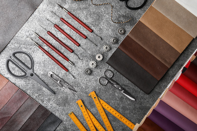 Flat lay composition with leather samples and craftsman tools on grey stone background