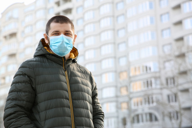 Man wearing disposable mask outdoors. Dangerous virus